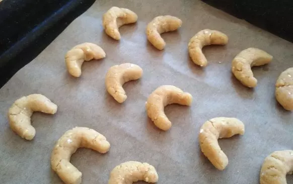 Do moučné směsi nasekejte 35 g másla. Třecím nástavcem v robotu a nebo vidličkou do směsi máslo zapracujte - pracujte rychle, aby se suroviny co nejméně zahřály.

Když je mouka s máslem rozemnutá do jemné drobenky, přidejte žloutky i rum a opět zapracujte.

Těsto rychle vyválejte do válečku a rozdělte na 15 stejných dílků. Z nich rychle vytvarujte rohlíčky.