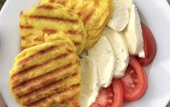 Mozzarellu vyndáme z nálevu. Všechny suroviny smícháme, rozmixujeme tyčovým mixérem v hrníčku a dáme do mikrovlnky na cca 4 minuty.

 Poté vyklopíme (pokud si předtím vymažeme hrnek tukem, půjde to lépe), rozřízneme napůl (nejlépe to jde nití) a opečeme na grilu dozlatova.