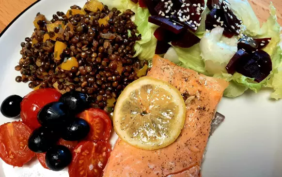 1. Predehřejte troubu na 200°C.
2. Lososa omyjte a dejte do pekáčku lehce vytřeného olejem. Lososa také jemně potřete olejem, dochuťte solí, pepřem a šťávou z citrónu.
3. Cherry rajčata nakrájejte na poloviny a spolu s olivami dejte do pekáčku k lososovi. Lososa můžete dozdobit plátky  citrónu.
4. Pečte v troubě cca 20 minut, aby byl losos propečený, ale stále šťavnatý.