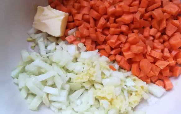 Cibuli, česnek a mrkev oloupejte a nakrájejte nadrobno. Rozpalte máslo a osmahněte vše dozlatova. Rajčata nakrájejte na menší kousky a přidejte k podušené cibuli a vařte cca 5 minut.
Pak vše zalijte vývarem, přisypte žlutou čočku a vařte 15-20 minut doměkka.
Kari pastou nebo kari kořením a solí dochuťte vývar. Nakonec přidejte zakysanou smetanu, kterou už nevaříte.
Posypte nakonec pažitkou a podávejte. Pečivo ani příloha není potřeba. Pokud to máte řídké, můžete trošku zahustit mletými ovesnými vločkami nebo celozrnnou moukou.
Já jsem pažitku neměla, tak je fotka bez pažitky.