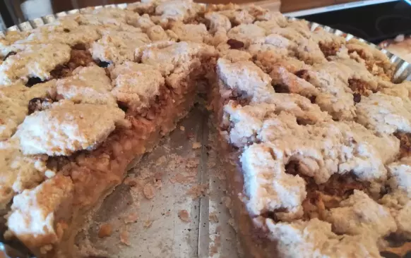 Na těsto nastrouháme oloupaná jablka, posypeme skořicí a mletými/nasekanými ořechy, pokapeme rumem.
Pokryjeme druhým dílem těsta nebo jej můžete nastrouhat, propíchneme vidličkou a dáme do středně vyhřáté trouby zvolna péct. Když je povrch lehce růžový/křupavý, je koláč hotový.