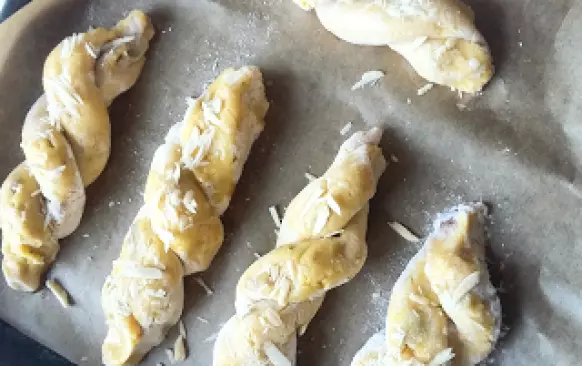 přendáme je na plech vystlaný pečicím papírem, potřeme rozpuštěným kokosovým olejem a 
         posypeme mandlemi (oba konce můžeme propíchnout malou špejlí, aby se nerozmotaly při
         pečení)